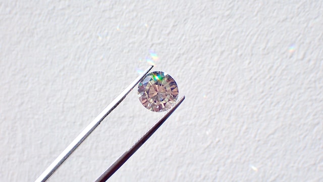 a diamond being held by a pair of tweezers